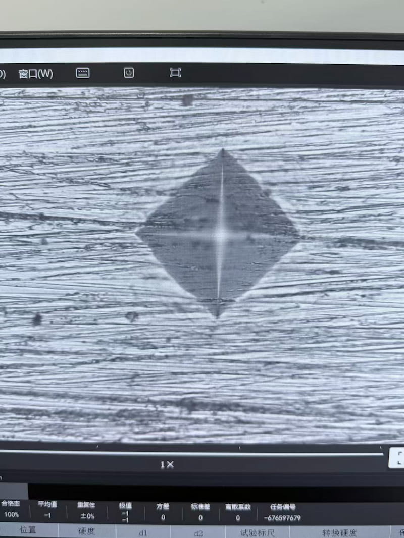 Diamond-shaped Vickers hardness indentation on a prepared steel abrasive specimen Diamond-shaped Vickers hardness indentation on a prepared steel abrasive specimen