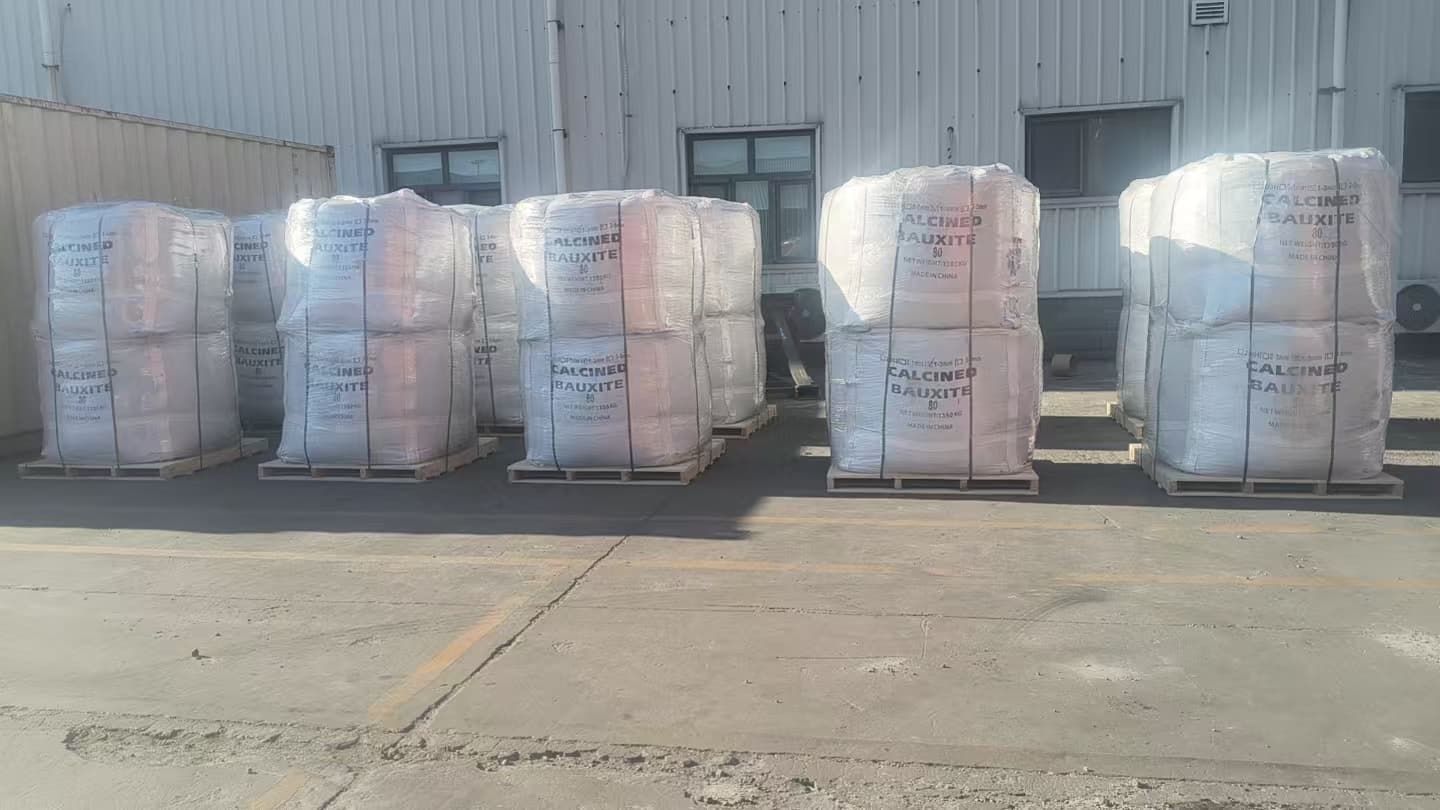 Pallets of bagged calcined bauxite prepared outside a warehouse
